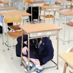 大掃除中に放送が流れ、その場で頭を守る生徒ら＝いずれも２２日、兵庫県立舞子高校