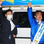 石井登志郎氏（右）の勝利に向けて拳を突き上げる、自民党兵庫県連会長の西村康稔衆院議員＝２５日午後、西宮市高松町（撮影・斎藤雅志）