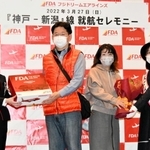 式典で花束や記念品を受け取った搭乗者の代表（中央の２人）＝中央区、神戸空港