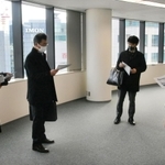 神戸市内の事業拠点開設に向けて、オフィス物件を見て回る東京のアニメ制作会社の社員（左端の２人）ら＝同市中央区