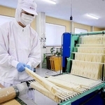 揖保乃糸の「小引き工程」の機械作業（県手延素麺協同組合提供）