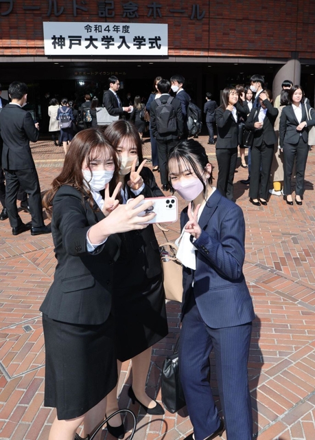 入学式会場前で記念写真を撮る新入生＝５日午前、神戸市中央区港島中町６（撮影・小林良多）