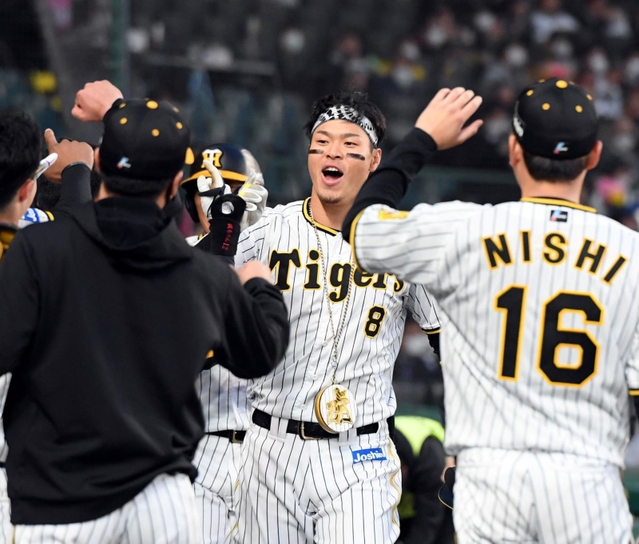 １回に２点本塁打を放ち、ナインに迎えられる阪神の佐藤輝明内野手＝甲子園（撮影・山口　登）