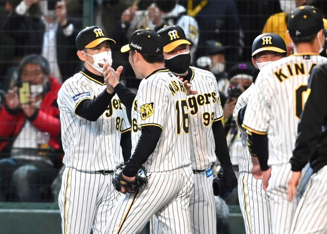完封勝利を挙げた阪神の西勇輝投手（左から２人目）とタッチを交わす矢野燿大監督（左端）＝５日夜、甲子園（撮影・田中太一）