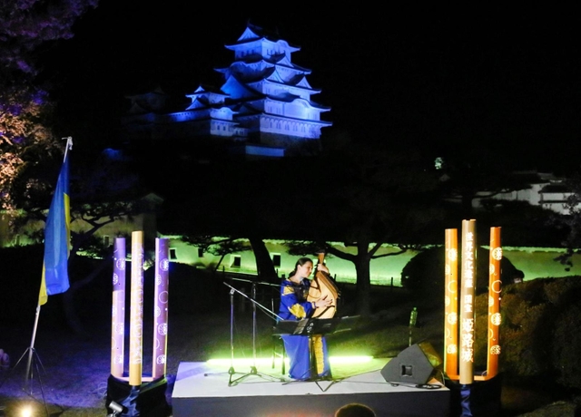 ウクライナ国旗の色に染まった会場で、平和を祈る音色を響かせるカテリーナ・グジーさん＝８日夜、姫路城（撮影・大山伸一郎）