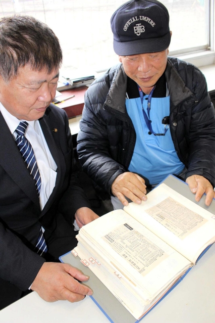 赤穂軟式野球協会の選手成績を集めたスクラップブックを手にする永安弘理事長（右）ら＝赤穂市加里屋