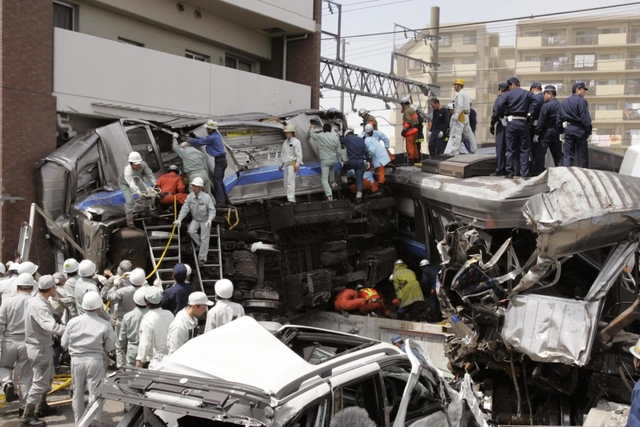 原形をとどめない状態の車両で乗客の救助に当たる人たち＝２００５年４月２５日午前１０時３８分、兵庫県尼崎市潮江４