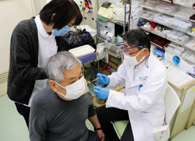 新型コロナワクチンを患者に接種する診療所の医師（右）。「欠勤者が出ても何とかしのぐしかない」と語る＝神戸市東灘区本山北町２、口分田玄瑞診療所