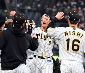 １回に２点本塁打を放ち、ナインに迎えられる阪神の佐藤輝明内野手＝甲子園（撮影・山口　登）