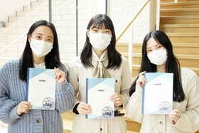 完成したノートを手にする甲南女子大の学生＝神戸市東灘区森北町６（兵庫県提供）