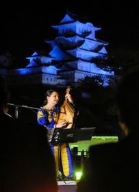 ウクライナ国旗の色に染まった会場で、平和を祈る音色を響かせるカテリーナ・グジーさん＝８日夜、姫路城（撮影・大山伸一郎）