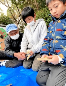 山本辰也さんにアドバイスされながら、木や竹を削る子どもたち＝神戸市須磨区横尾６