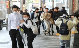ゴールデンウイークの初日、神戸・三宮の繁華街では傘を手にした若者らを猛烈な風が襲った＝２９日午後、神戸市中央区加納町４（撮影・鈴木雅之）