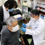 新型コロナワクチンを患者に接種する診療所の医師（右）。「欠勤者が出ても何とかしのぐしかない」と語る＝神戸市東灘区本山北町２、口分田玄瑞診療所