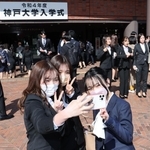 入学式会場前で記念写真を撮る新入生＝５日午前、神戸市中央区港島中町６（撮影・小林良多）