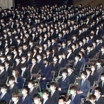 神戸大学の入学式で、話に耳を傾ける新入生。感染対策で間隔を空けて座り、マスクを着用した＝５日午前、神戸市中央区港島中町６（撮影・小林良多）