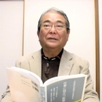 「反省が執筆のきっかけ」と著書を手にする早川利文さん＝明石市内