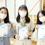 完成したノートを手にする甲南女子大の学生＝神戸市東灘区森北町６（兵庫県提供）
