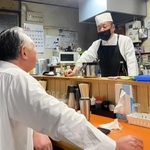 カウンター越しに常連客との会話が弾む石川博純さん（右）＝年金食堂