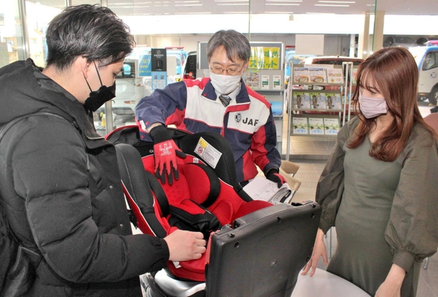 子どもが生まれる前の準備で、チャイルドシートの無料点検に訪れた夫婦＝神戸市灘区鹿ノ下通２、ＪＡＦ兵庫支部