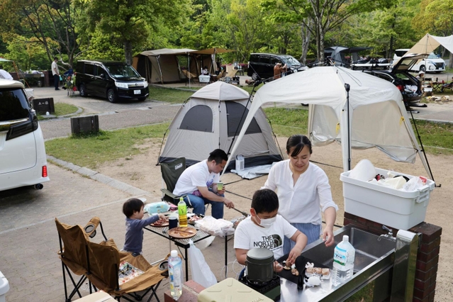 夕食づくりを楽しむ家族。大型連休中、キャンプ場には多くの利用者が訪れた＝７日午後、神戸市北区のしあわせの村オートキャンプ場（撮影・長嶺麻子）