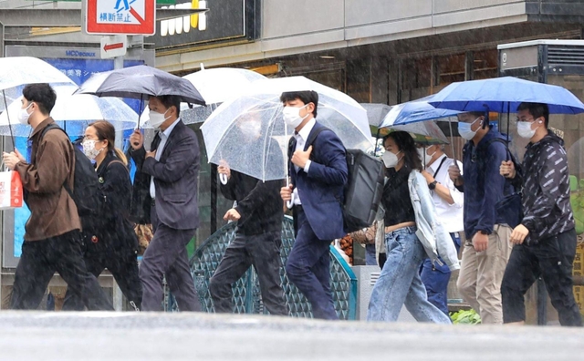 雨の街を行き交う人々＝１２日午後、神戸市中央区布引町４（撮影・吉田敦史）