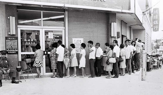 ドルと円を交換するため、琉球銀行の前に並ぶ人たち＝１９７１年撮影、沖縄県公文書館所蔵