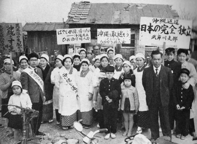 沖縄返還を求め、行進に臨む武庫川支部の会員たち。「沖縄を取り返そう」の文字が見える＝１９５９年ごろ（「沖縄県人会兵庫県本部３５年史」より）