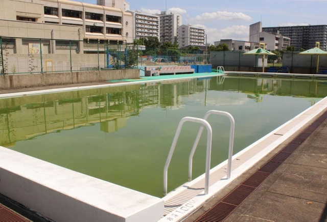 昨年使われなかった小学校のプール。消防用水の役割や底面の保護のため、水をためて管理していた＝２０２１年６月、神戸市内
