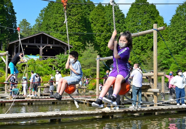 青空の下、水上アスレチックを楽しむ子どもら＝２２日午後、神戸市灘区六甲山町、グリーニア
