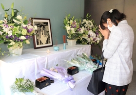 小尻知博さんの遺影に手を合わせる女性＝３日午後、西宮市与古道町、朝日新聞阪神支局
