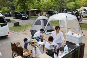 夕食づくりを楽しむ家族。大型連休中、キャンプ場には多くの利用者が訪れた＝７日午後、神戸市北区のしあわせの村オートキャンプ場（撮影・長嶺麻子）
