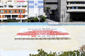 沖縄都市モノレールの駅から見えるよう、琉球銀行の敷地内に設置された復帰５０年記念の横断幕＝那覇市