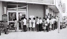 ドルと円を交換するため、琉球銀行の前に並ぶ人たち＝１９７１年撮影、沖縄県公文書館所蔵
