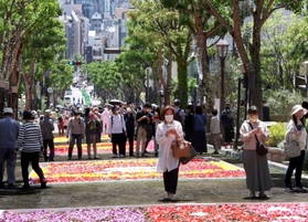 チューリップの花びらで描いた絵を並べたイベント「インフィオラータこうべ」が３年ぶりに開かれ、大勢の観光客らでにぎわった＝４月３０日、神戸市中央区