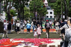 北野異人館街へ続く北野坂では３年ぶりにチューリップの花びらで描いた絵を並べたイベント「インフィオラータこうべ」が開かれた。大勢の観光客らでにぎわった＝４月３０日、神戸市中央区