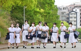 夏服のワンピースに身を包んで通学路を歩く生徒たち＝１６日朝、神戸市灘区王子町（撮影・秋山亮太）