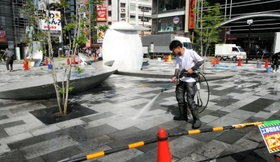 「さんきたアモーレ広場」の地面を洗浄する作業員＝神戸市中央区加納町４