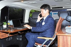 トヨタ自動車が開発した燃料電池車（ＦＣＶ）グランエース内に設けられた執務スペースの利用を体験する兵庫県の斎藤元彦知事＝兵庫県公館