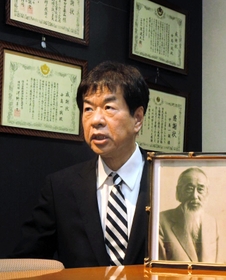 開業医として地域医療に取り組んだ祖父紀一さんの遺影を前にするナガタ薬品の中島康伸社長＝神戸市須磨区弥栄台１