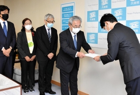 斎藤元彦知事（右）に要望書を手渡す「つなぐ会」代表理事の寺田真治さんら＝兵庫県庁