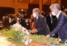 献花して手を合わせる参列者たち＝２８日午後、丹波篠山市立田園交響ホール
