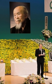 遺族を代表してあいさつする、長男の河合透さん＝２８日午後、丹波篠山市立田園交響ホール