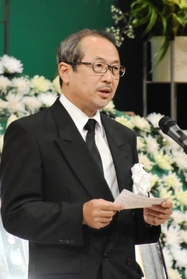 遺族を代表してあいさつする、長男の河合透さん＝２８日午後、丹波篠山市立田園交響ホール
