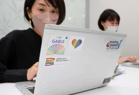 パソコンにアライのワッペンを貼るＰ＆Ｇジャパンの社員。デザインに「暗闇の向こうにある明かりになれれば」との思いが込められる＝Ｐ＆Ｇジャパン本社