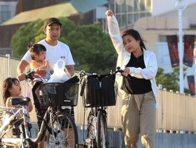 汗を拭うようなしぐさの女性＝２９日夕、神戸市中央区波止場町（撮影・吉田敦史）