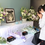 小尻知博さんの遺影に手を合わせる女性＝３日午後、西宮市与古道町、朝日新聞阪神支局