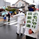 兵庫県警が指定した「おもいやり横断歩道」で横断歩道の歩行者優先を呼び掛ける警察官ら＝３月１８日、神戸市長田区細田町３