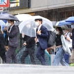 雨の街を行き交う人々＝１２日午後、神戸市中央区布引町４（撮影・吉田敦史）