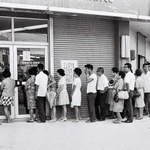 ドルと円を交換するため、琉球銀行の前に並ぶ人たち＝１９７１年撮影、沖縄県公文書館所蔵